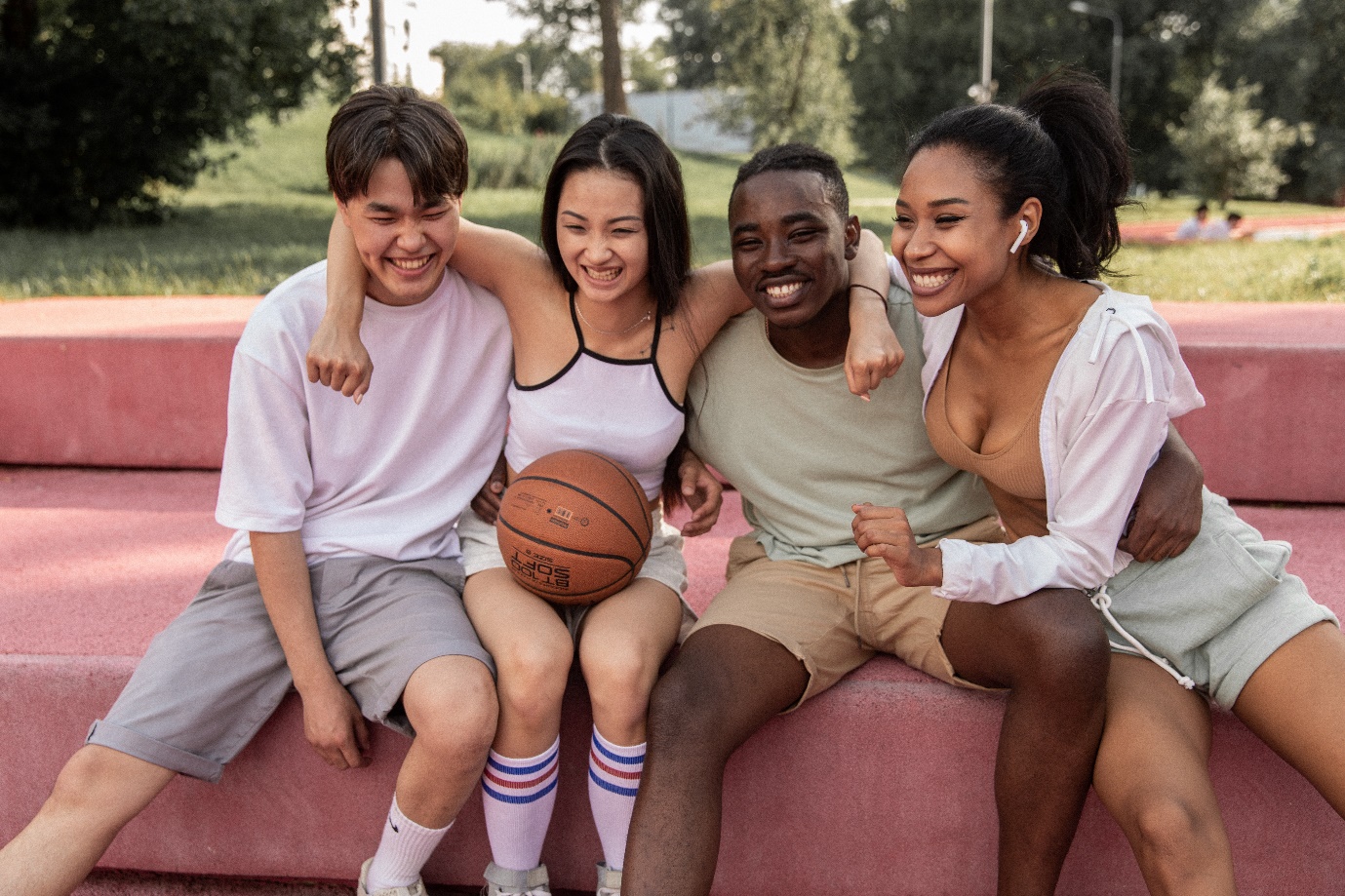 A group of people sitting on a bench with a basketball

Description automatically generated with medium confidence